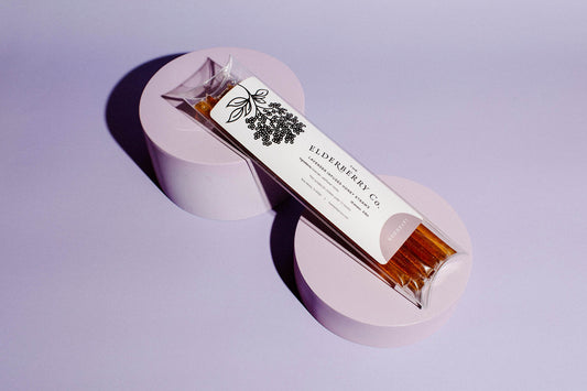 Bar of soap with a label on a purple stand against a light purple background