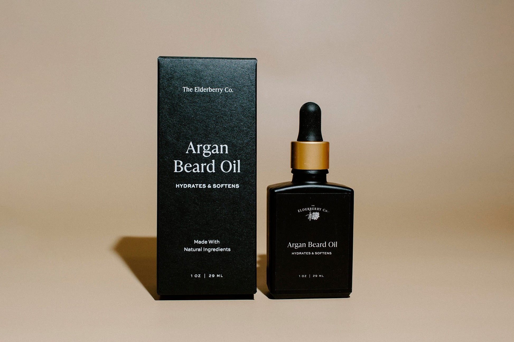 Argan beard oil bottle and packaging on a beige background