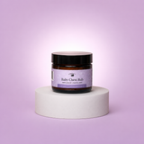 Jar of 'Baby Chest Rub' on a white pedestal against a light purple background