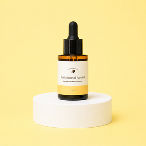 Bottle of Daily Renewal Face Oil on a white pedestal with a yellow background