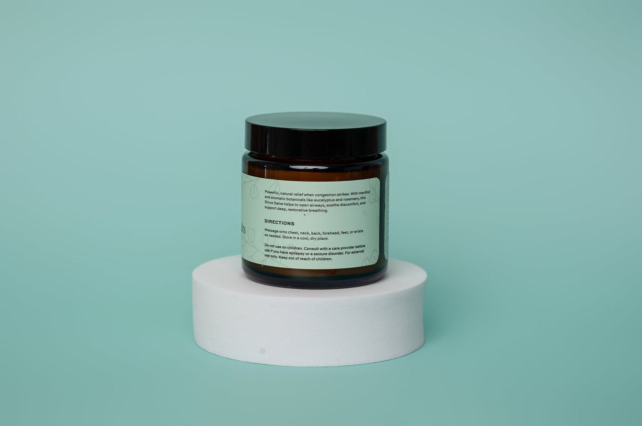 Jar with a label on a white cylindrical platform against a light blue background