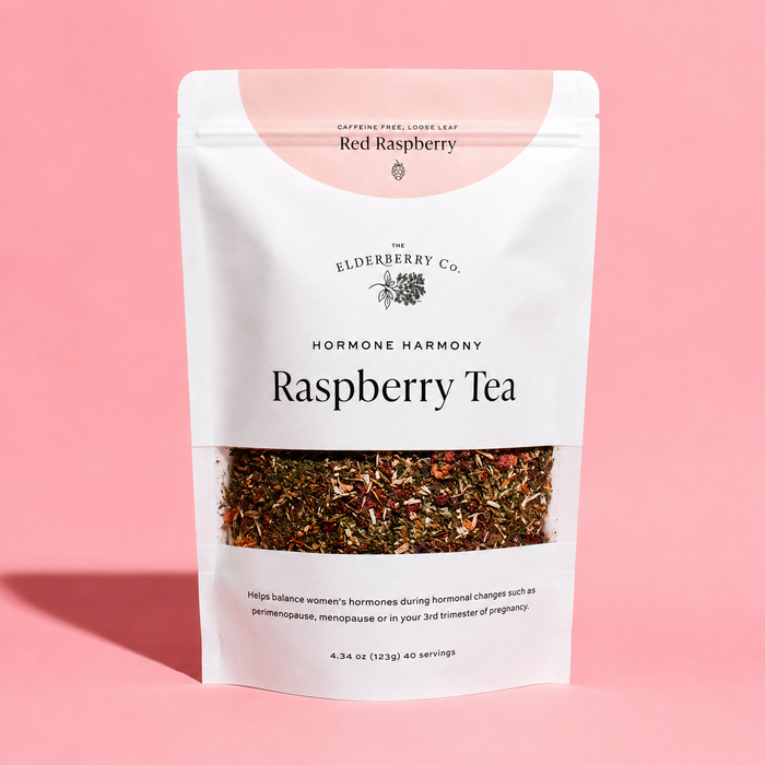 A stand-up pouch of Elderberry Co. Raspberry Tea on a solid pink background.