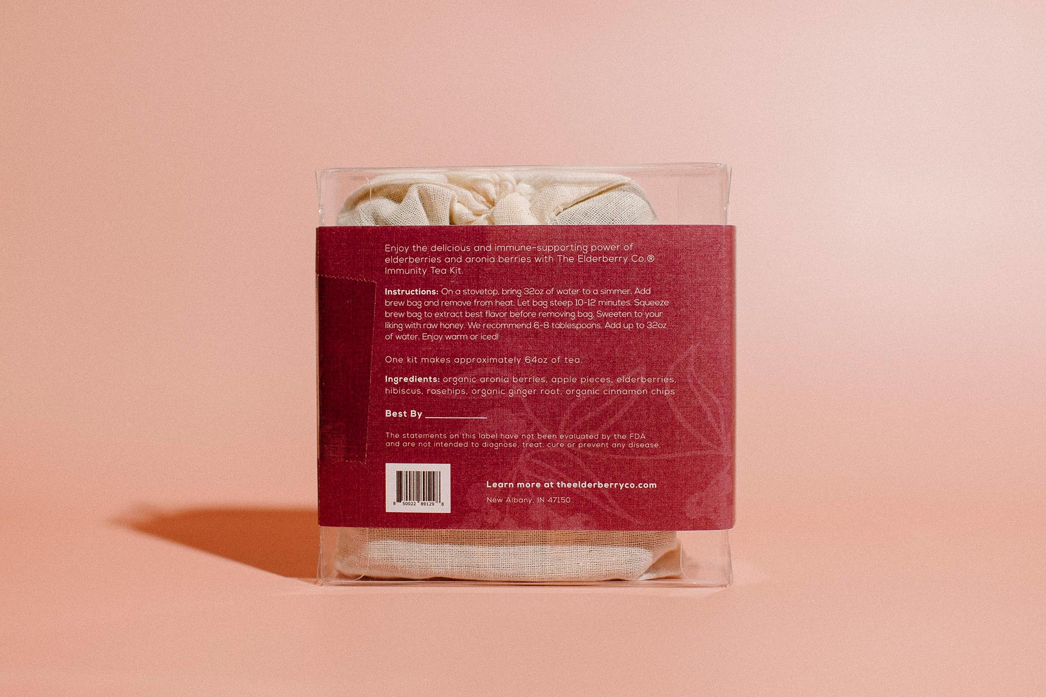 Back view of The Elderberry Co. Immunity Tea Kit showing brewing instructions, ingredients, and product information in clear gift packaging against a soft pink background.