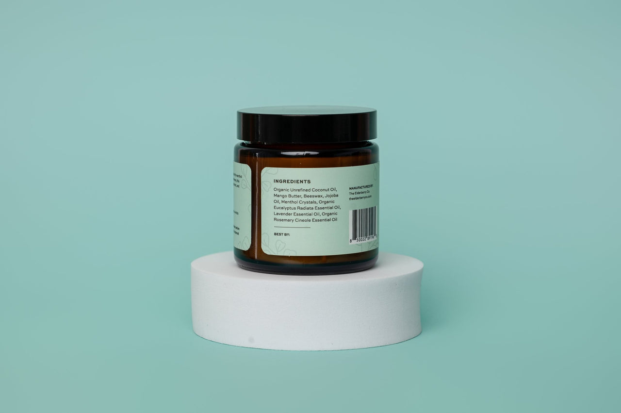Jar of sinus salve ingredients with a label on a white platform against a light blue background