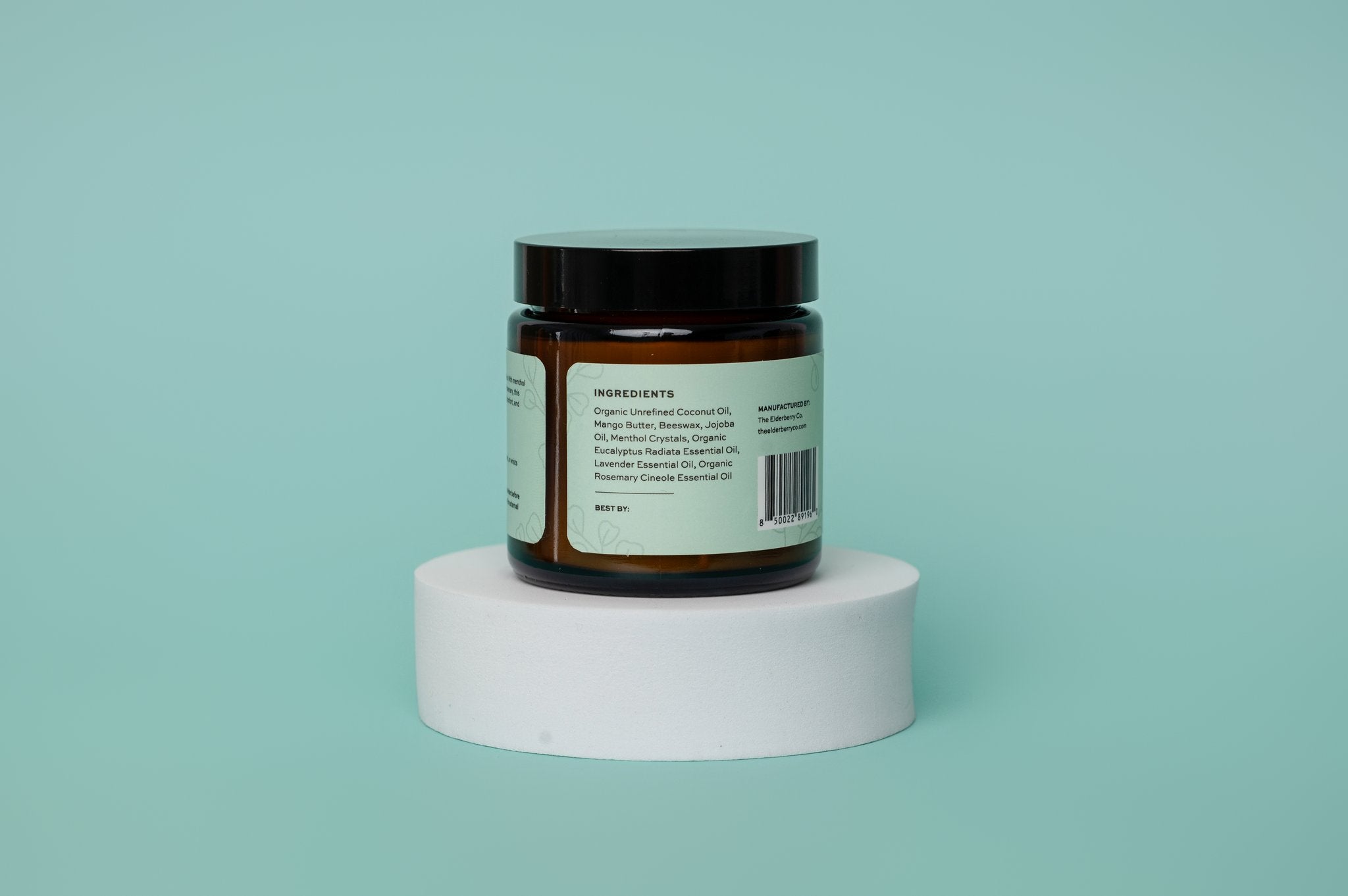 Jar of sinus salve ingredients with a label on a white platform against a light blue background
