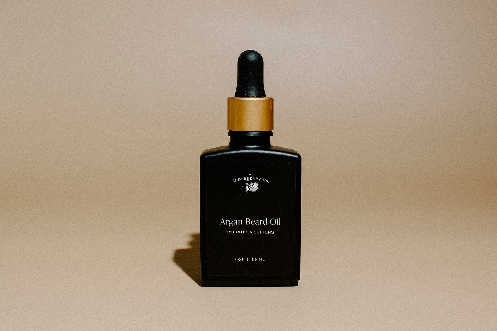 Front view of Elderberry Co. Argan Beard Oil in a black glass dropper bottle with a gold cap, formulated to hydrate, soften, and nourish beards.