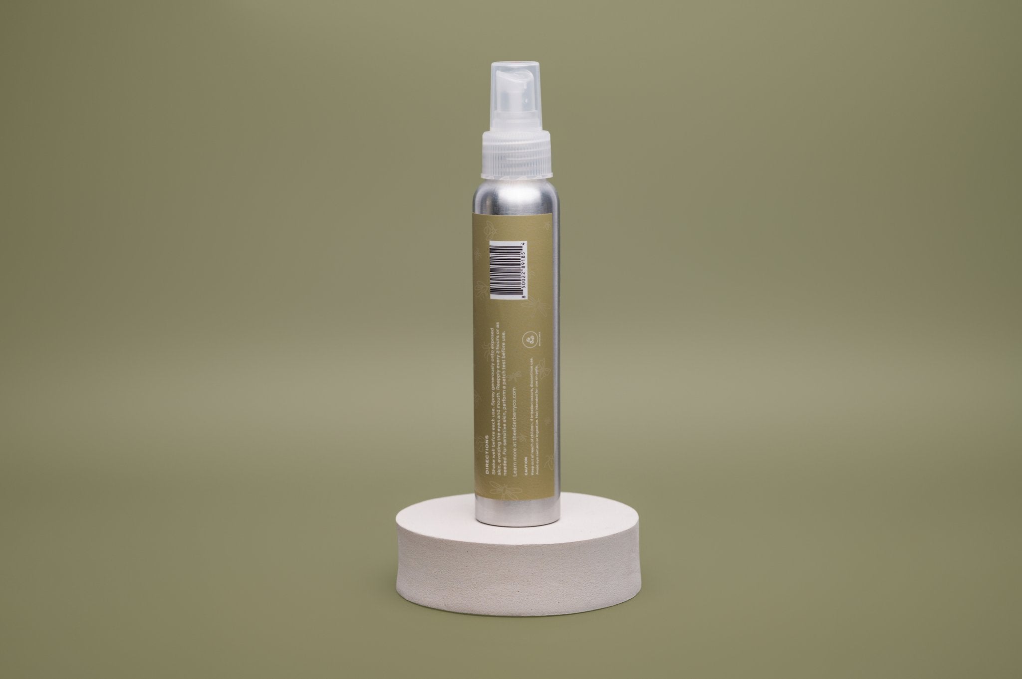 Spray bottle on a white stand against a beige background