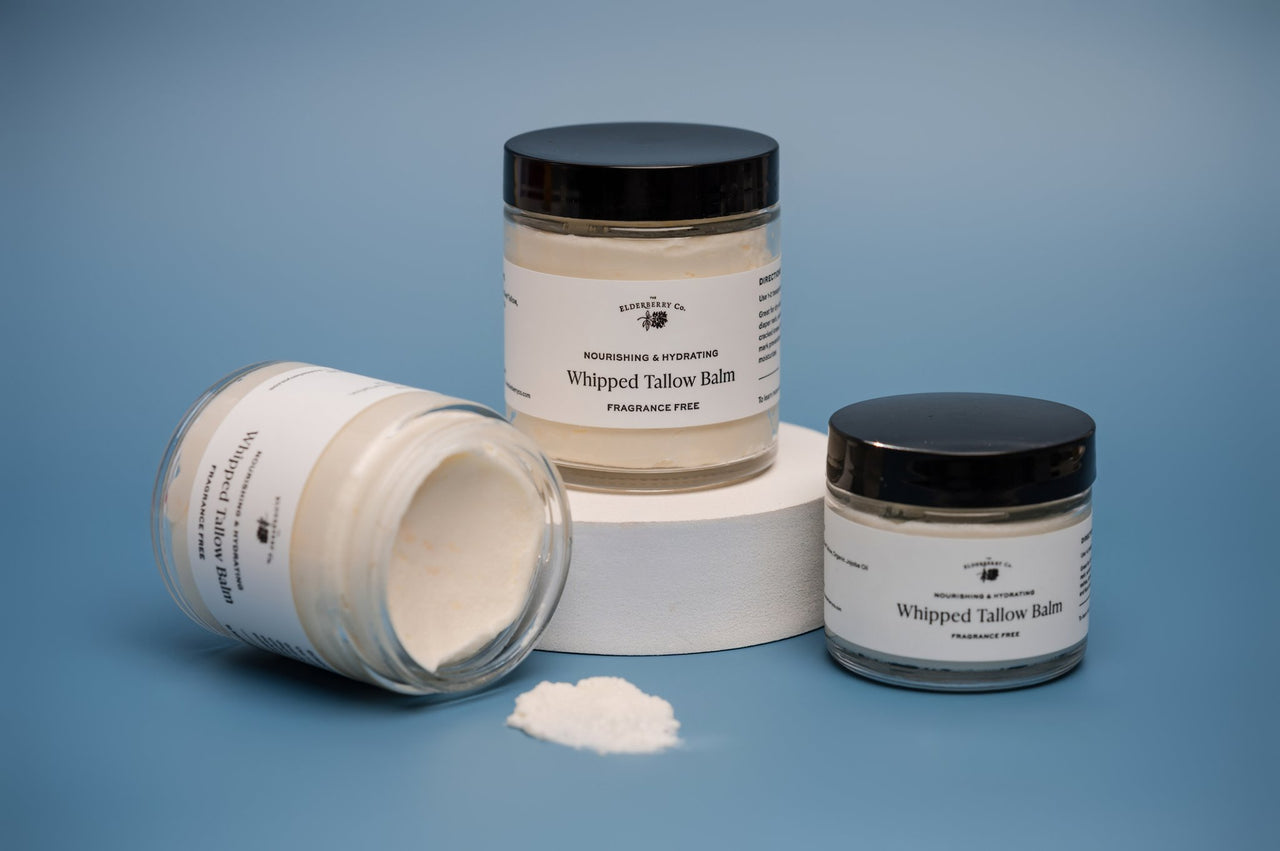 Three jars of whipped tallow balm on a blue background