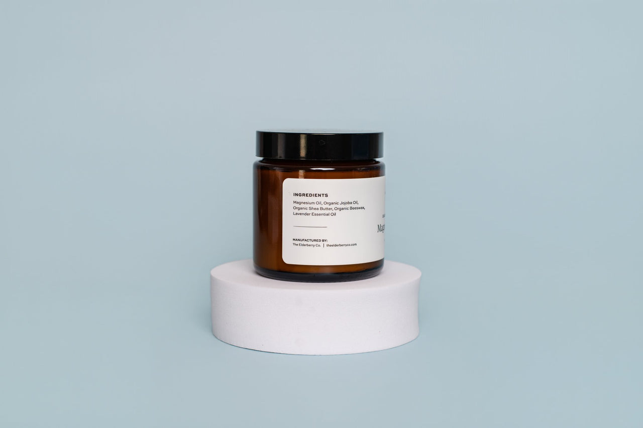 Brown jar with a label on a white pedestal against a light blue background